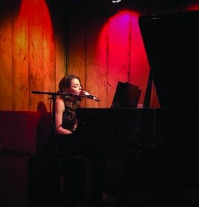 Alycia Mayhew playing on a grand piano.