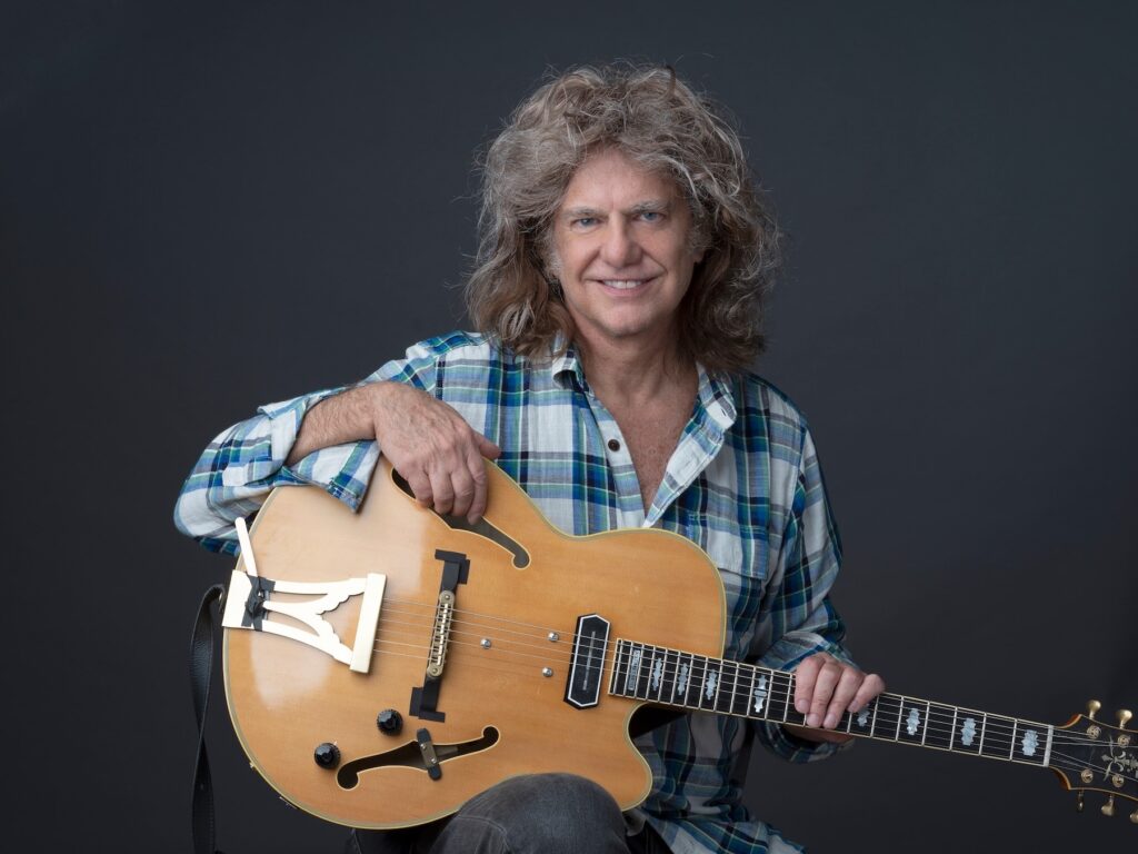Pat Metheny holding a guitar